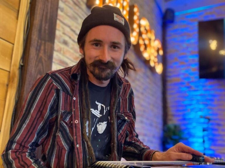 Justin smiling at the camera while seated behind his pedal steel.