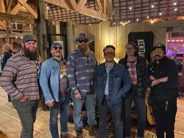 Band members standing in a line in a converted barn before playing a show in Kentucky.